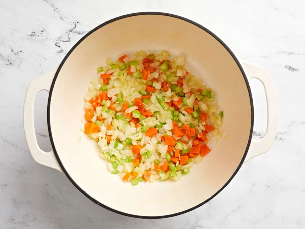 Overhead view of veggies being sauteed in a Dutch oven pot.