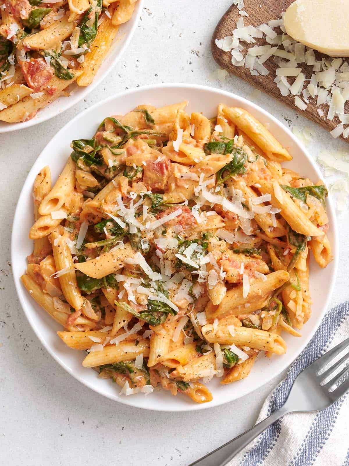 Overhead view of a plate of creamy tomato and spinach pasta.