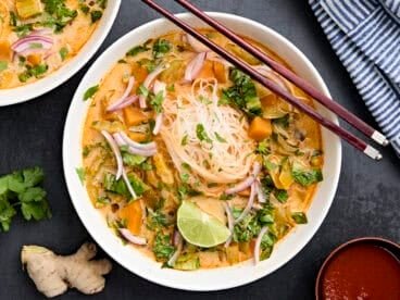 Overhead view of thai vegetable curry soup in a bowl with chopsticks.